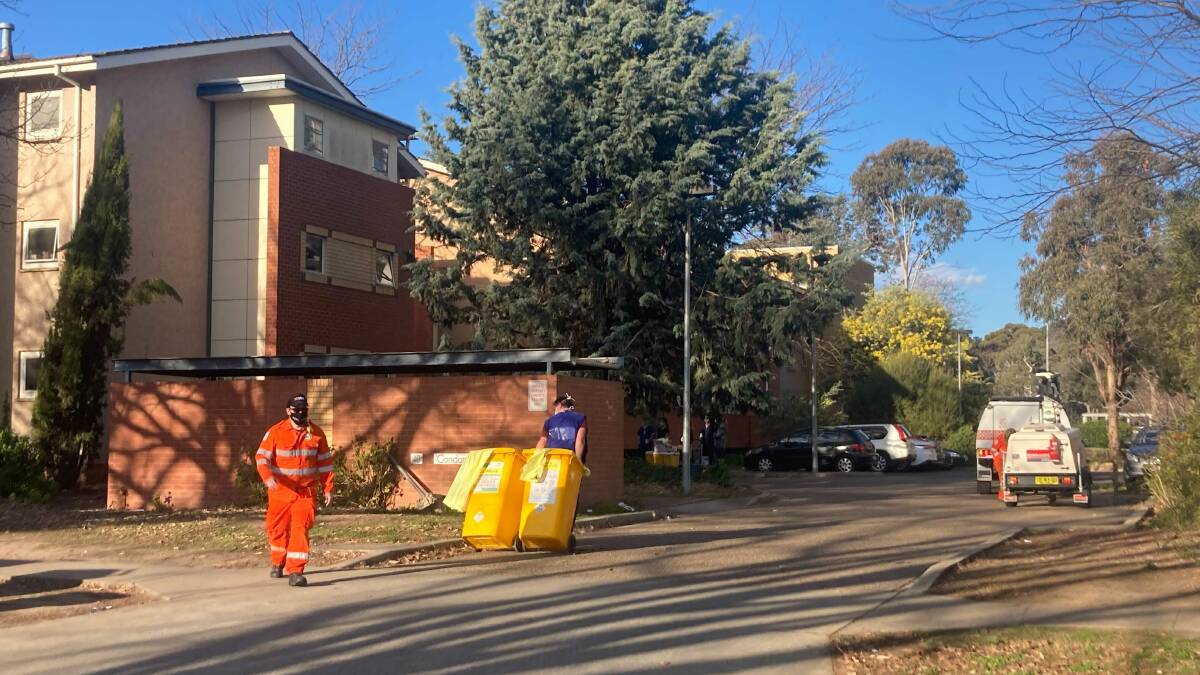 Volunteers swap over bins at Condamine Court on Sunday. Picture: Alex Crowe