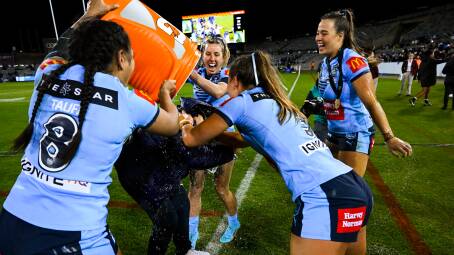 Sam Bremner, centre, helps deliver the traditional post-match Gatorade shower to Sky Blues coach Kylie Hilder on Friday. Picture: AAP