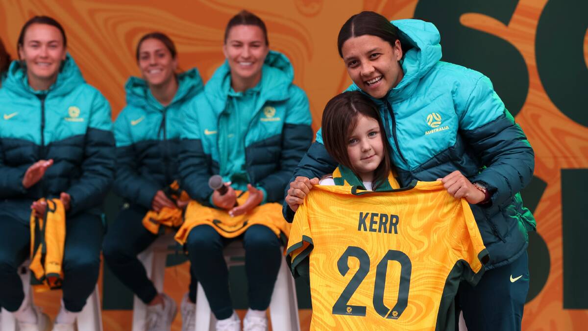 Matildas captain Sam Kerr embraces Matilda Cash, 6, from Kambah, in Melbourne's Federation Square last week. Picture Getty Images
