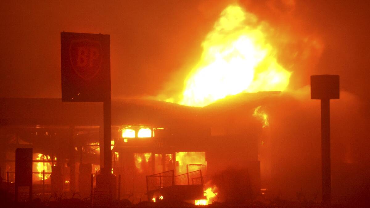 A service station in Duffy goes up in flames during Canberra's 2003 bushfire. Picture by Andrew Campbell