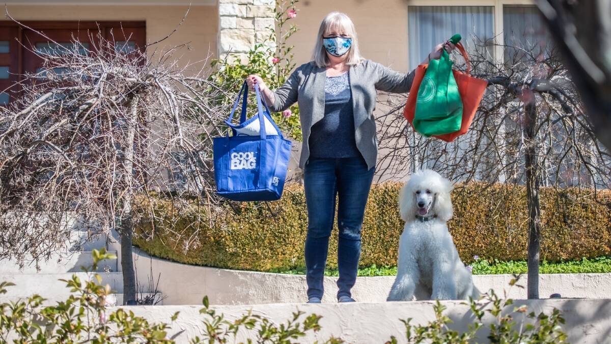 Willing shoper Debbie Hart, of Nicholls, with dog Zoe, is among the Canberrans that have offered to pick up groceries for people in quarantine. Picture: Karleen Minney