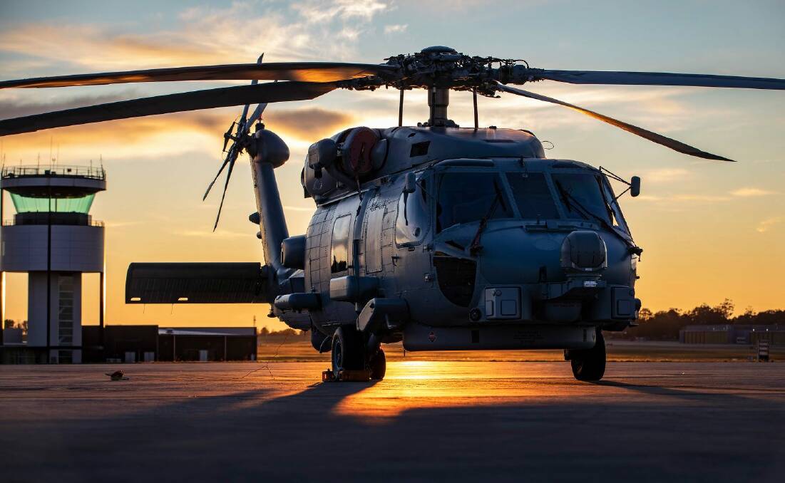 TROUBLE: A MH-60R Romeo helicopter from 816 Squadron silhouetted against the morning sun on the flight line at HMAS Albatross. Photo: Cameron Martin