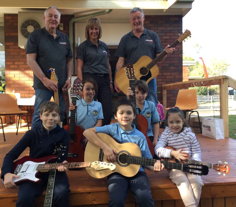 READY TO GO: Bomaderry Public students (from left) Dustin Peters, Charlotte Whittaker, Logan Peters, Sam Whittaker and Alexis Peters receive their guitars from ACT-based Soldier On Music Group members Col Greef and Mike Hogan and Soldier On programs officer Debbie Dimmock.