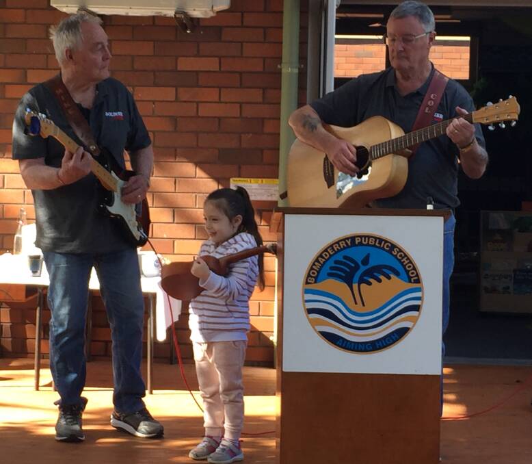 STAR: Five-year-old Alexis Peters stole the show at Bomaderry Public School, joining Soldier On Music Group members Mike Hogan and Col Greef on stage during their performance.