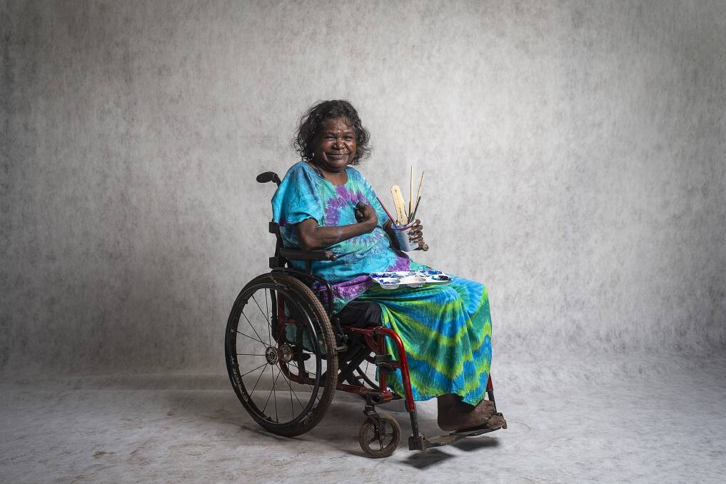 Dhambit Mununggurr has been painting in her signature blue acrylic for only a few years, after a car accident in 2007 left her with serious brain damage and almost took her life. Image: Rhett Hammerton/NGV