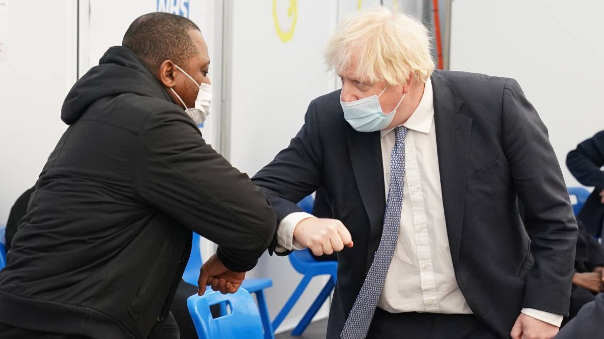 Prime Minister Boris Johnson greets members of the public as he arrives to receive his booster jab at a vaccination clinic in London. Picture: Getty Images