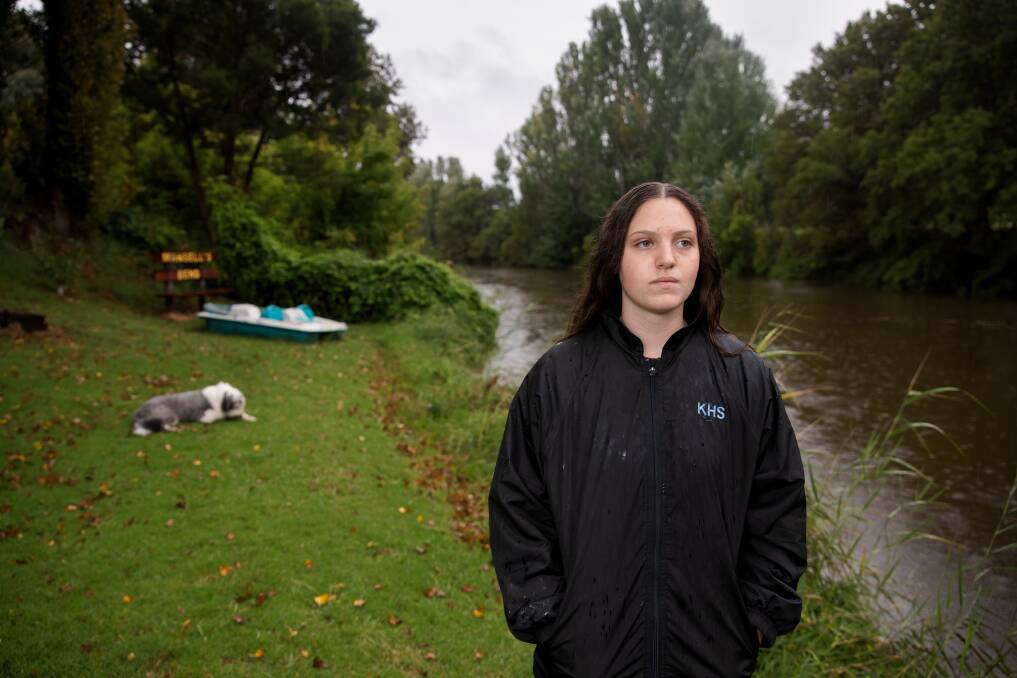 Holly Mansell watches the Queanbeyan River rise at her back yard. Picture: Sitthixay Ditthavong