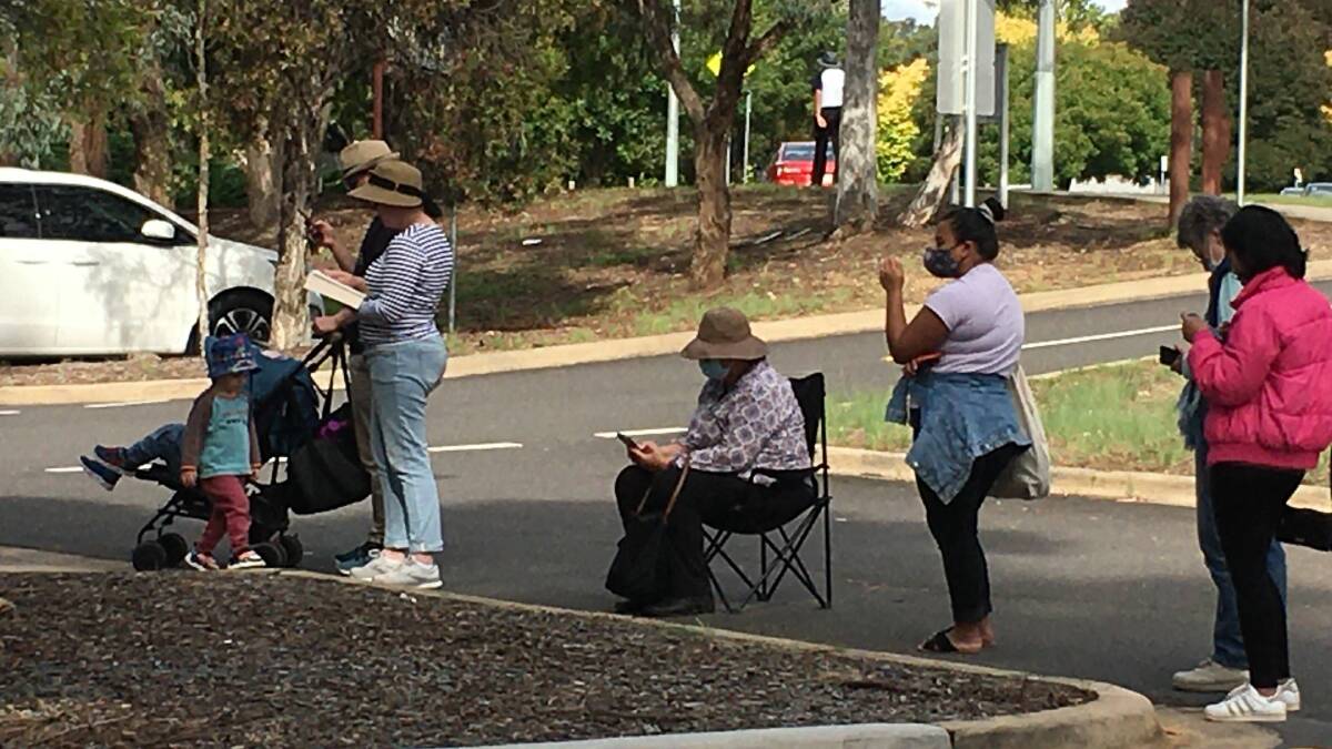 People have brought camping chairs while they wait to get a COVID-19 test at the Weston Creek clinic. Picture: Supplied