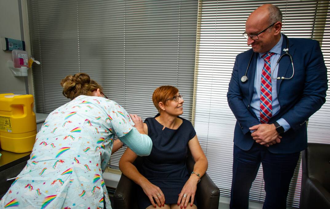Health Minister Rachel Stephen-Smith receives a vaccine from nurse Felicity Sander and pictured with former AMA ACT president, Dr Antonio Di Dio. Picture: Elesa Kurtz