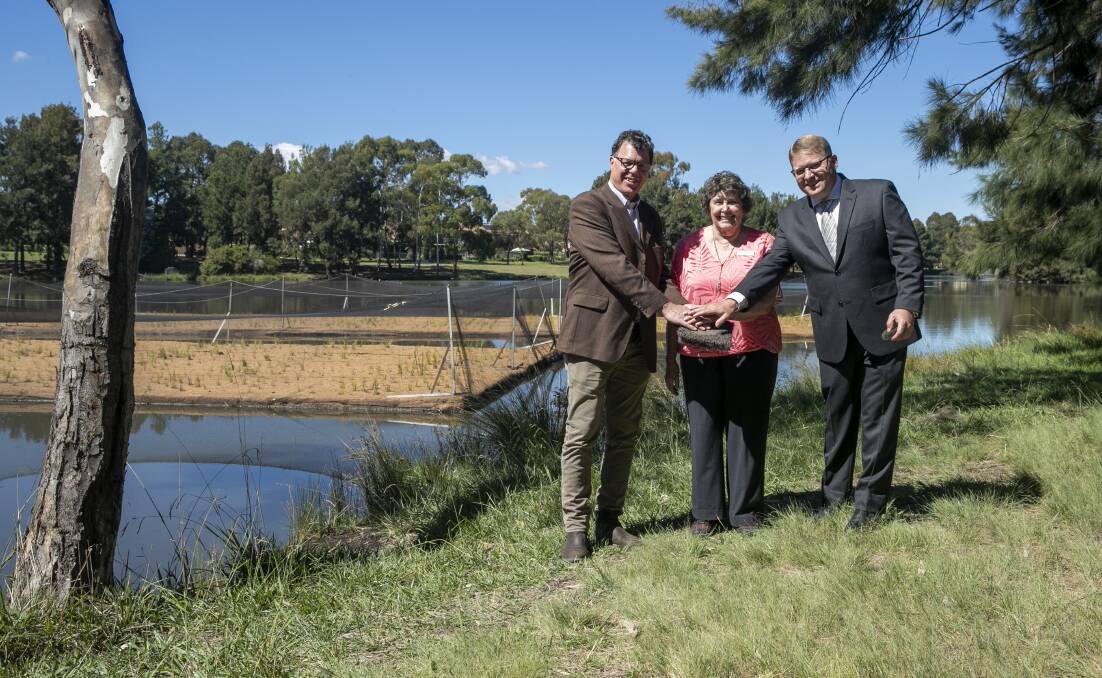 ACT Healthy Waterways manager Ralph Ogden, Southern ACT Catchment Group chair Glenys Patulny and Andrew Buggins from SPEL Stormwater inspect the new floating wetland in Lake Tuggeranong. Picture: Keegan Carroll