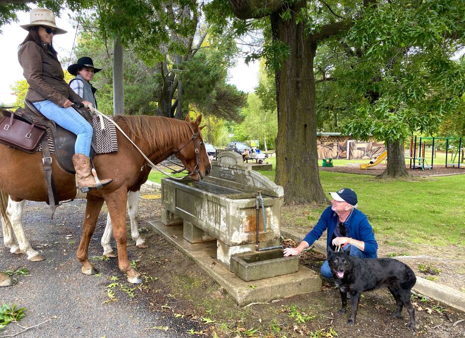 Peter Marshall and bitsa Allie join Jo Brissenden (on Copper) and her niece Claire Hall (on Pippi) at the trough which also has a smaller section especially designed for dogs. Picture by Tim the Yowie Man