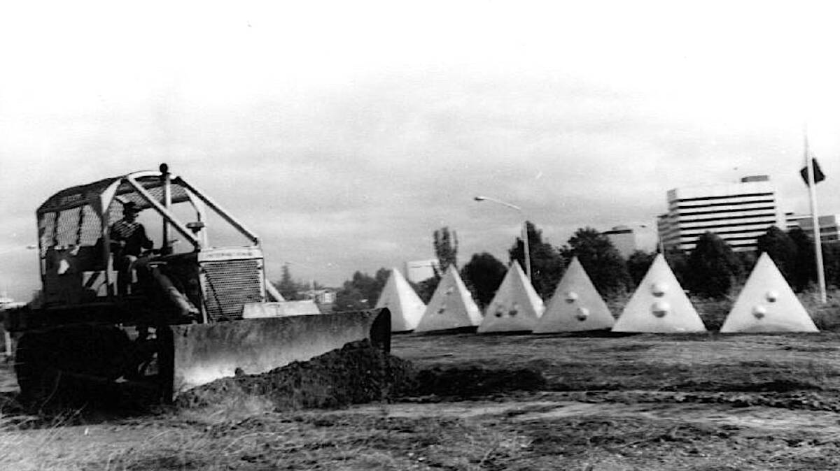 A trench is dug in 1975 for Bert Flugelman's six waiting polished steel tetrahedrons. Picture: Archives ACT
