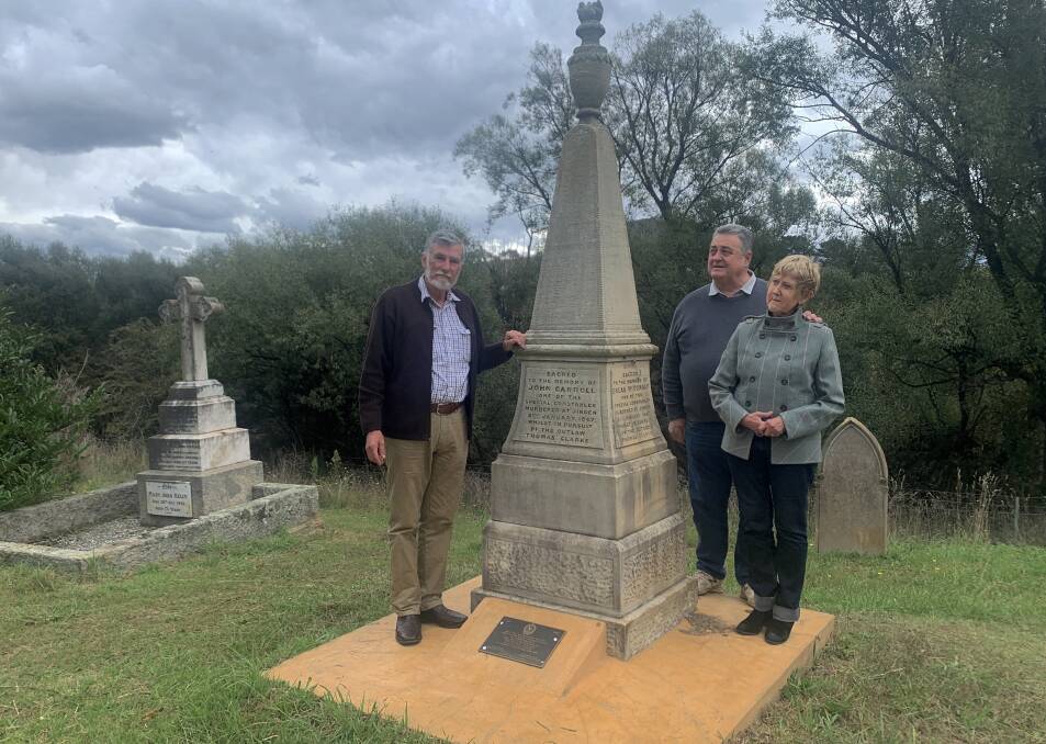 Peter Smith, left, with fellow bushranger aficionados Paul and Annette Briggs at the monument in Braidwood Cemetery dedicated to the four murdered special constables. Picture: Tim the Yowie Man