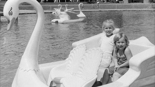 Alison Stanton, 8 and sister Renee, 3, enjoy the swan boat ride at Canberry Fair in December 1984. Picture: Peter Wells, The Canberra Times