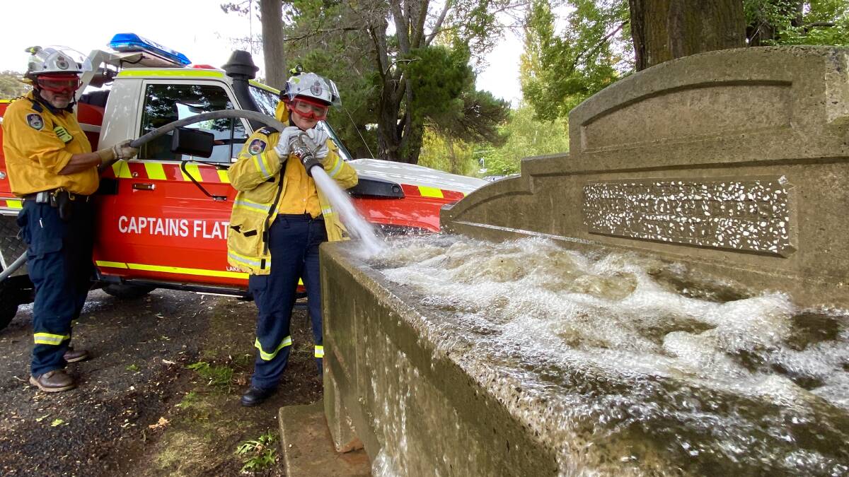 John Gough and Christina Steele of the Captains Flat Rural Fire Brigade give their historic town's trough a welcome flush out. Picture by Tim the Yowie Man