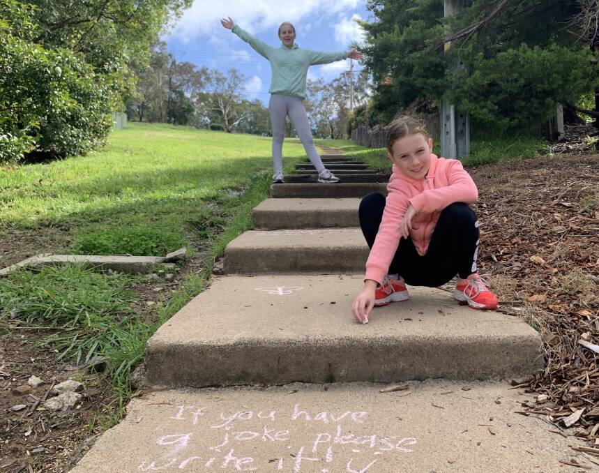 Tim's daughters Sarah and Emily chalk their own jokes on the stairs at Mt Rogers in Belconnen. Picture: Tim the Yowie Man
