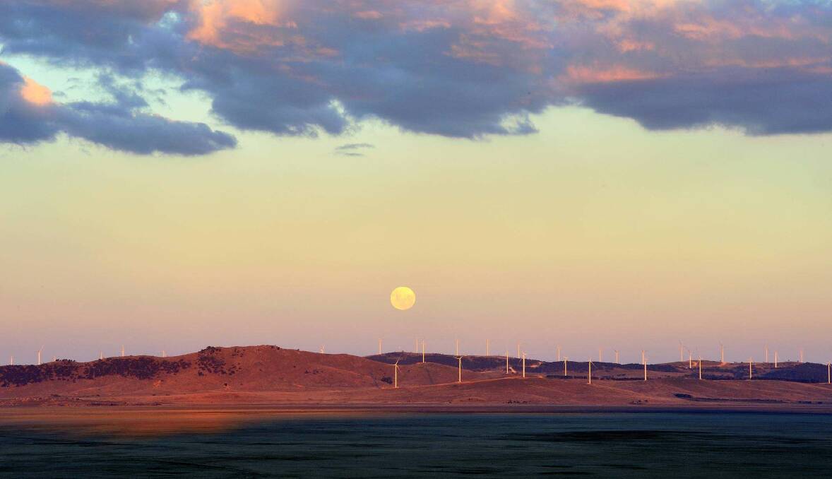 Just add water: Sydney musician Bill Risby snapped this striking photo of the moon rising above Lake George's wind turbines while driving past in May 2009. Picture: Bill Risby