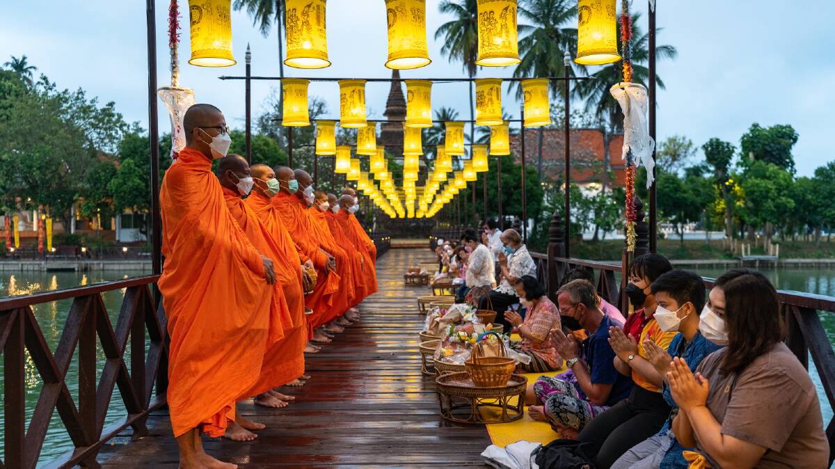 Monks in Sukhothai accept offerings of food from local residents at sunrise. Pictures: Michael Turtle