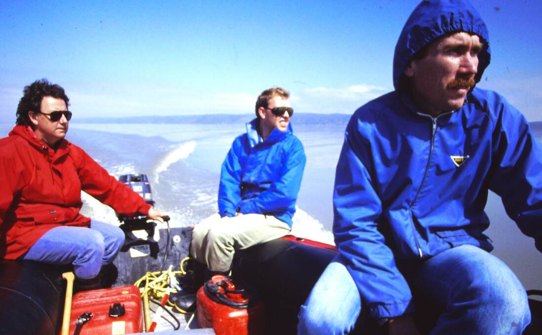 Dr Ian Young, right, and two fellow researchers rugged up and on their way to an overnight stay on the Lake George platform. Picture by Dr Ian Young