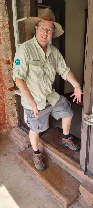 Tim straddles a step at a doorway which marks the significant watershed. Picture by Glenn Schwinghamer