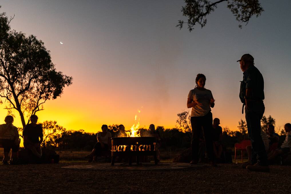 Guests gather around the fire for sunset drinks and a chat at Talaroo Hot Springs.