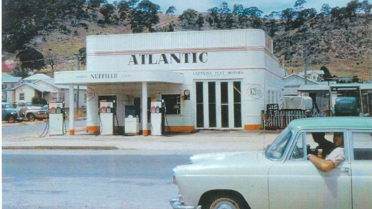 Atlantic Garage in Captains Flat in the 1960s. I wonder what flavour ice cream the two men in the car are eating! Picture by Karen Byrnes