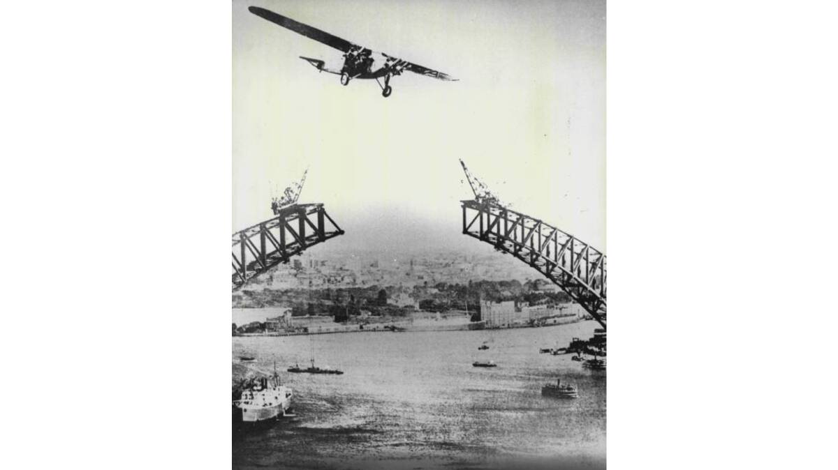 The Southern Cloud flies over an uncompleted Sydney Harbour Bridge. Picture by Barry John Stevens