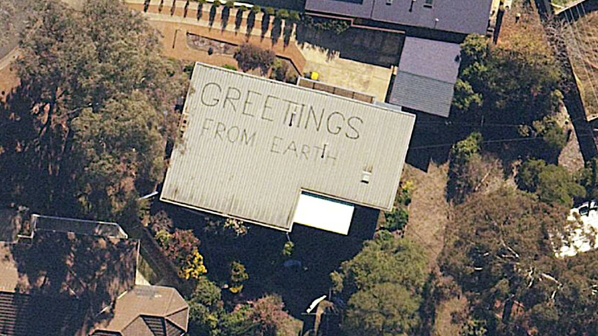 The earthly greeting message painted atop a house in Bindel Place, Aranda. Picture: ACTMapi