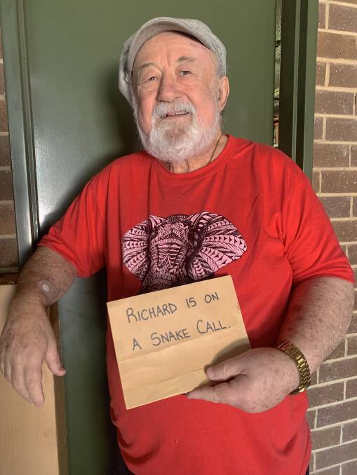 Ric Longmore with the sign he would hang on his office door when called out to remove a snake. Picture: Tim the Yowie Man