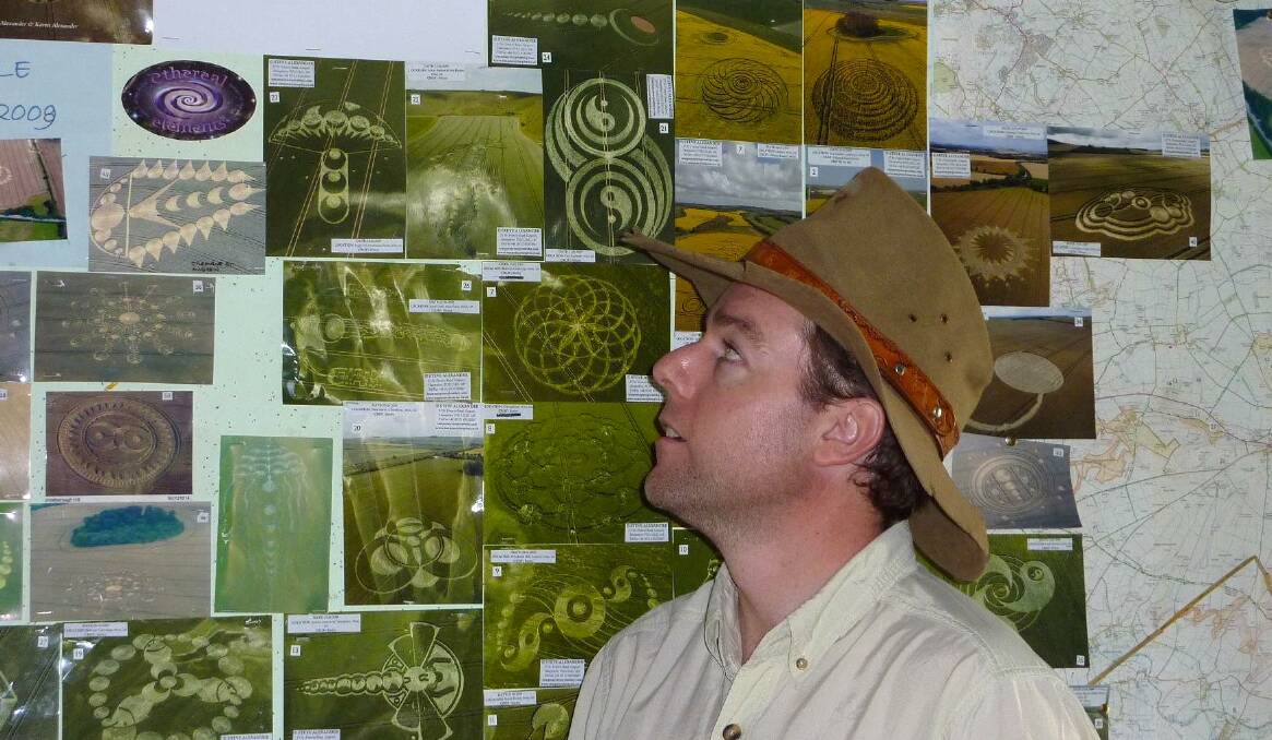 Tim checks out some of the photos of crop circles plastered on the wall of a pub in Wiltshire, England, in 2009. Picture by Tim the Yowie Man