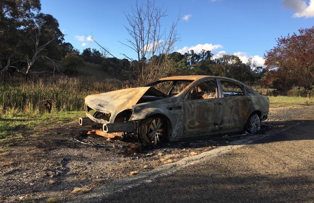 A stolen, burnt-out car by the roadside in a remote area of the ACT. Picture: Peter Brewer 