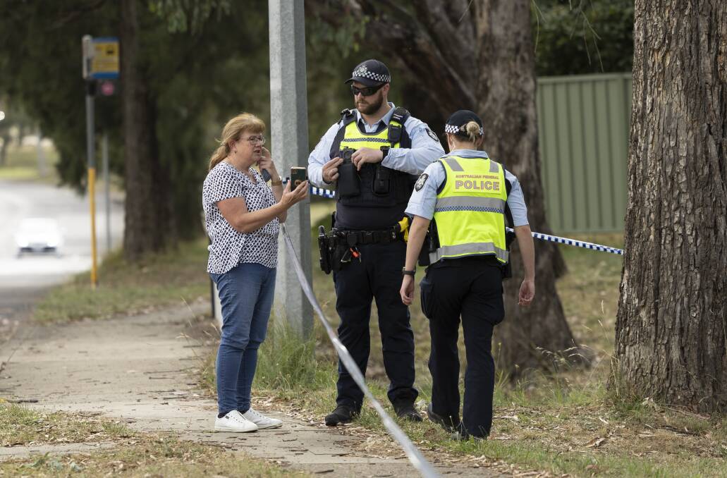 Police speak to a local resident at the cordon in Wanniassa. Picture by Keegan Carroll