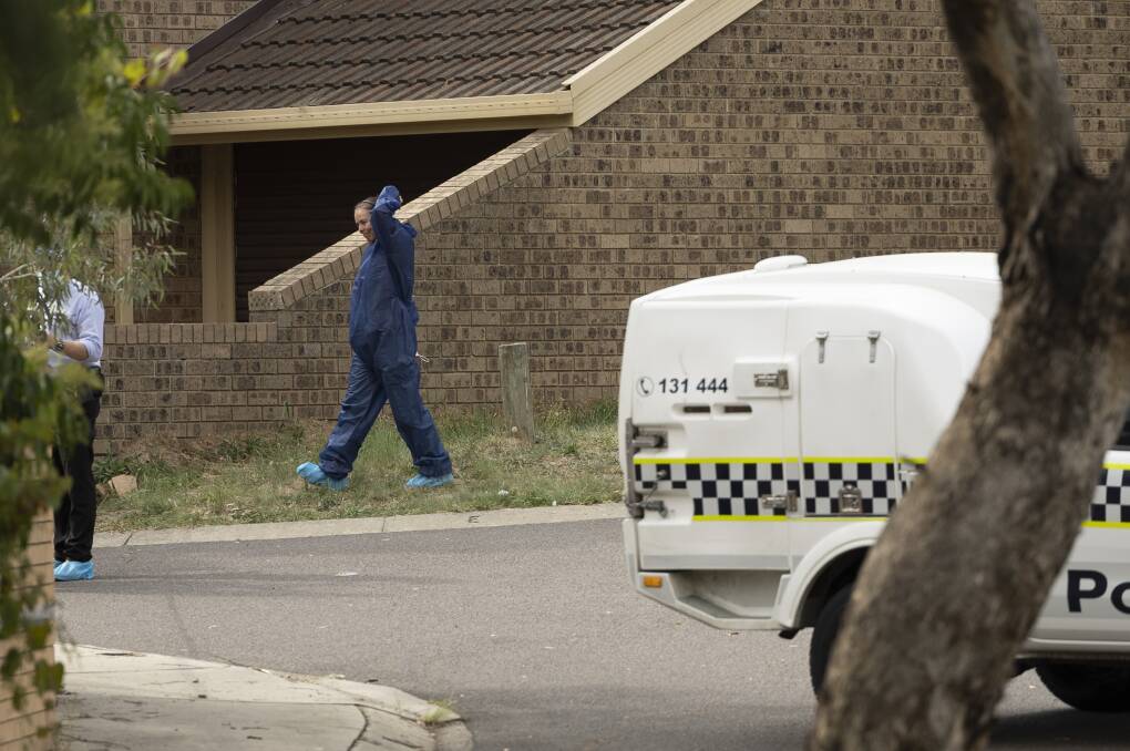 An officer in personal protective equipment at the Wanniassa incident. Picture by Keegan Carroll