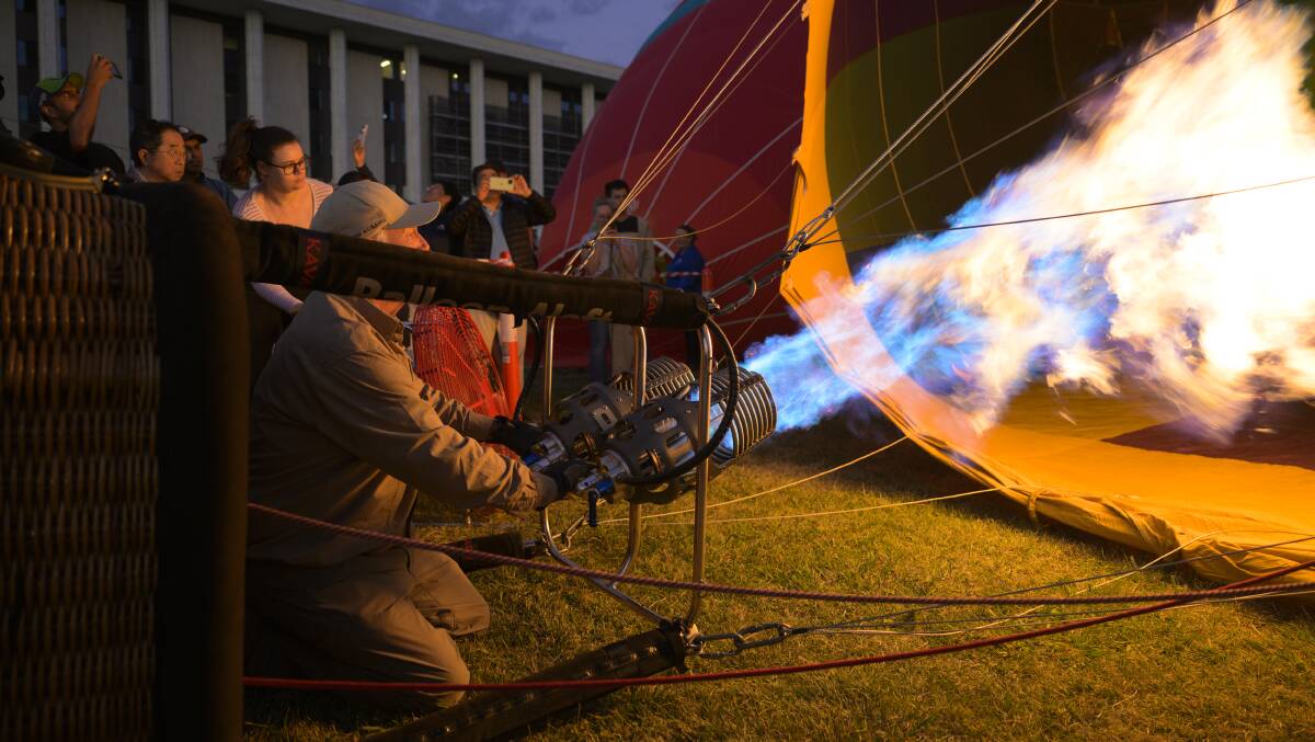 Pilot Graeme Scaife activates the burner to inflate his balloon. Picture by Keegan Carroll