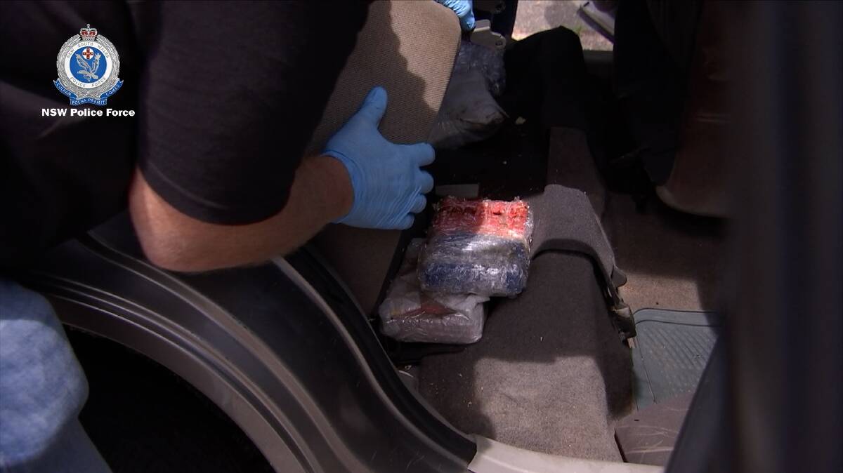 A cache of drugs hidden beneath the rear seat of a car is seized by police. Picture: NSW Police 