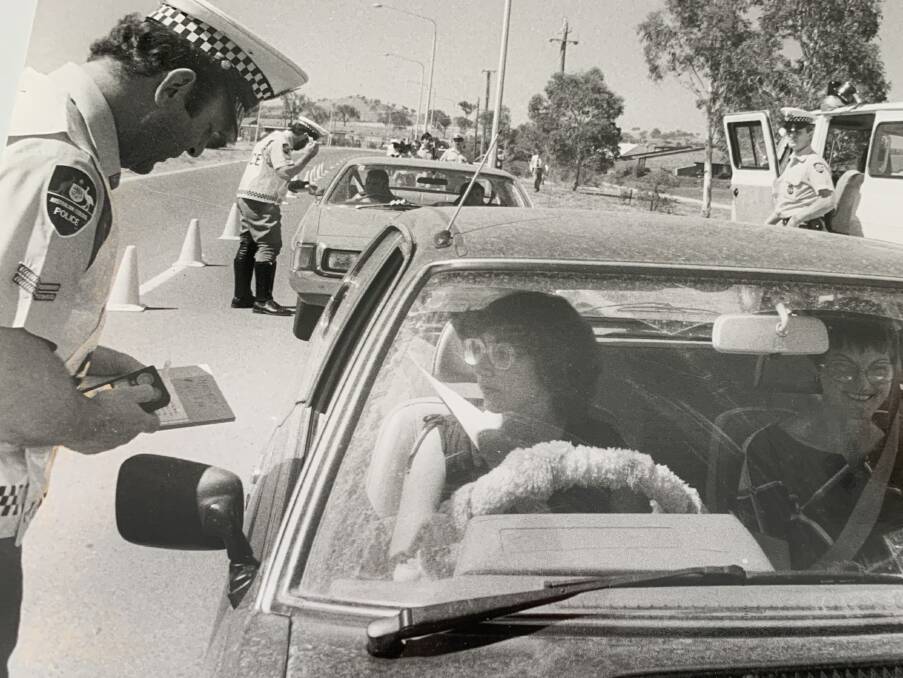 The official start to roadside breath testing in 1982, with Senior Constable Bill Mackie using the newest handheld equipment, which had progressed beyond the "blow in the bag". Picture: The Canberra Times