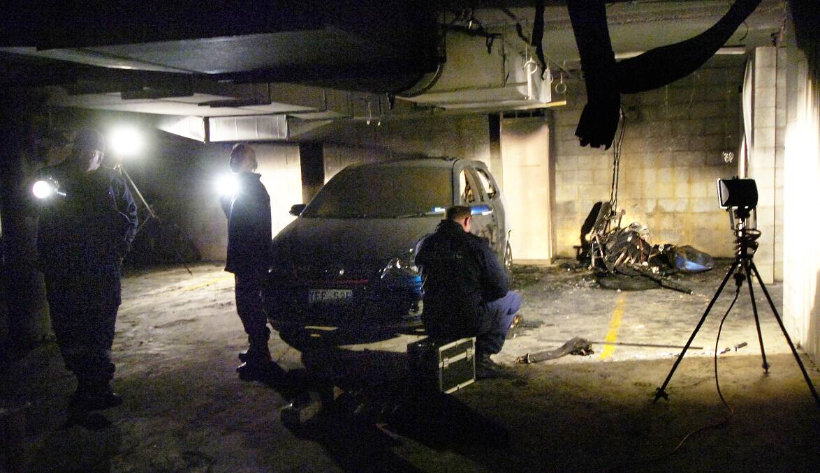 Police forensics examine a vehicle in a basement. Picture: Martin Jones 