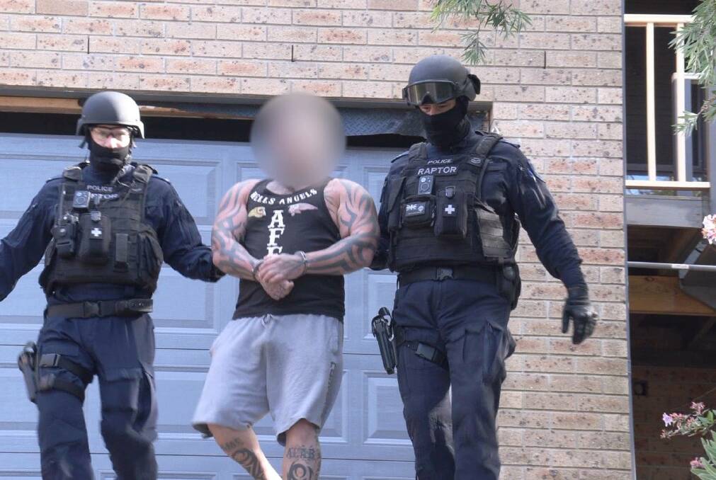 Members of Strike Force Raptor arrest the Hells Angels bikie at Mollymook. Picture: NSW Police