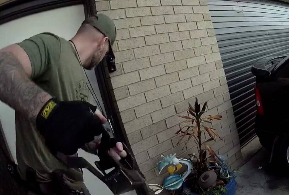 An Operation Toric member swings a door ram during a previous raid. Picture ACT Policing
