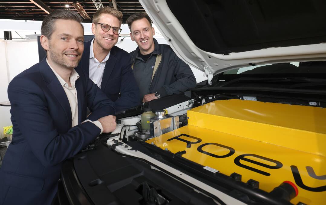 Roev's Lenny Cucksley, Noah Wasmer and Paul Slade, with their vehicle-to-grid battery pack under the bonnet of a conventional-looking Toyota Hilux. Picture: James Croucher