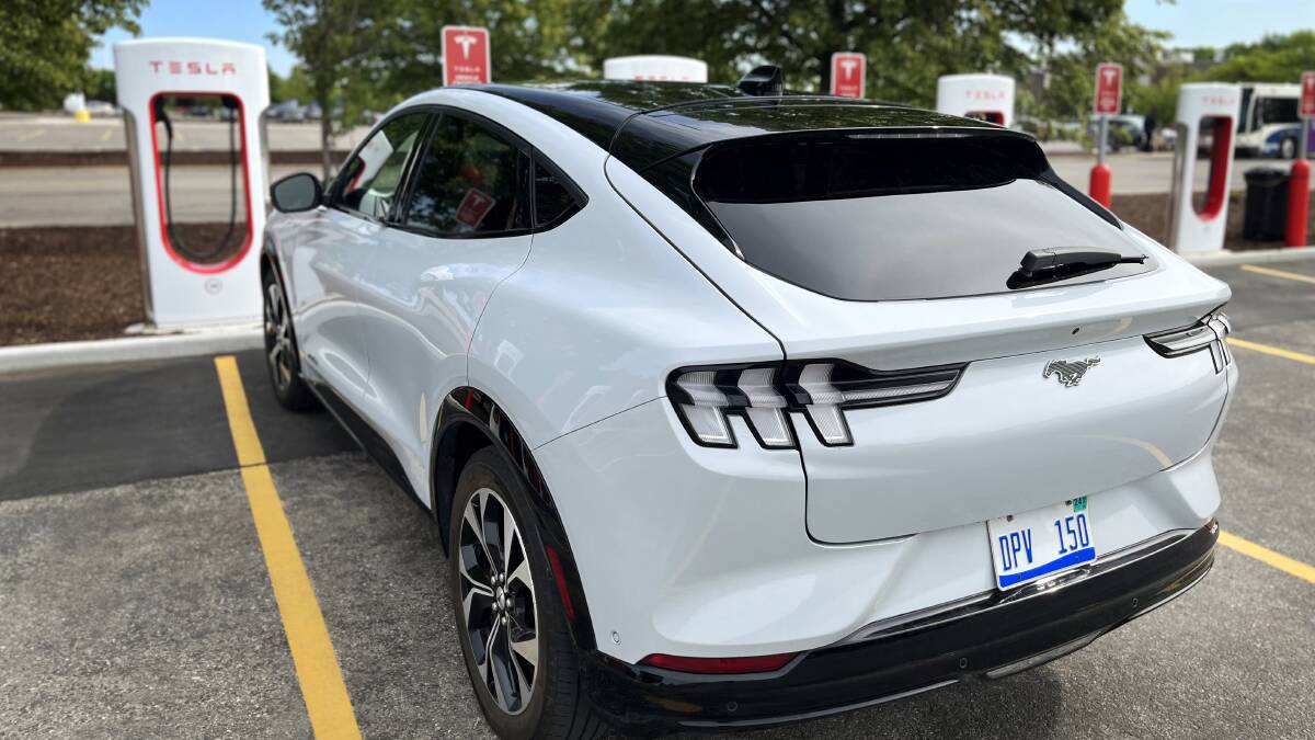 A Ford Mustang Mach-E EV hooks up to a Tesla supercharger. Picture supplied