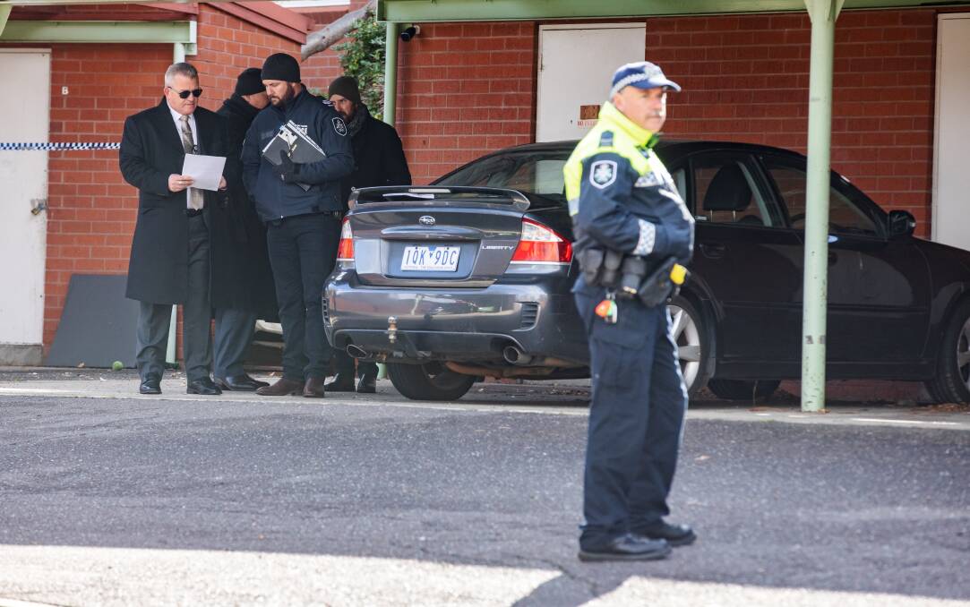 Detective Inspector Marcus Boorman, left, briefs his homicide team at the murder scene. Picture: Sitthixay Ditthavong
