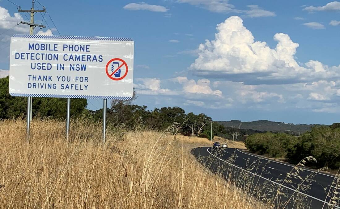 A mobile phone camera warning sign on the Federal Highway. Picture: Peter Brewer