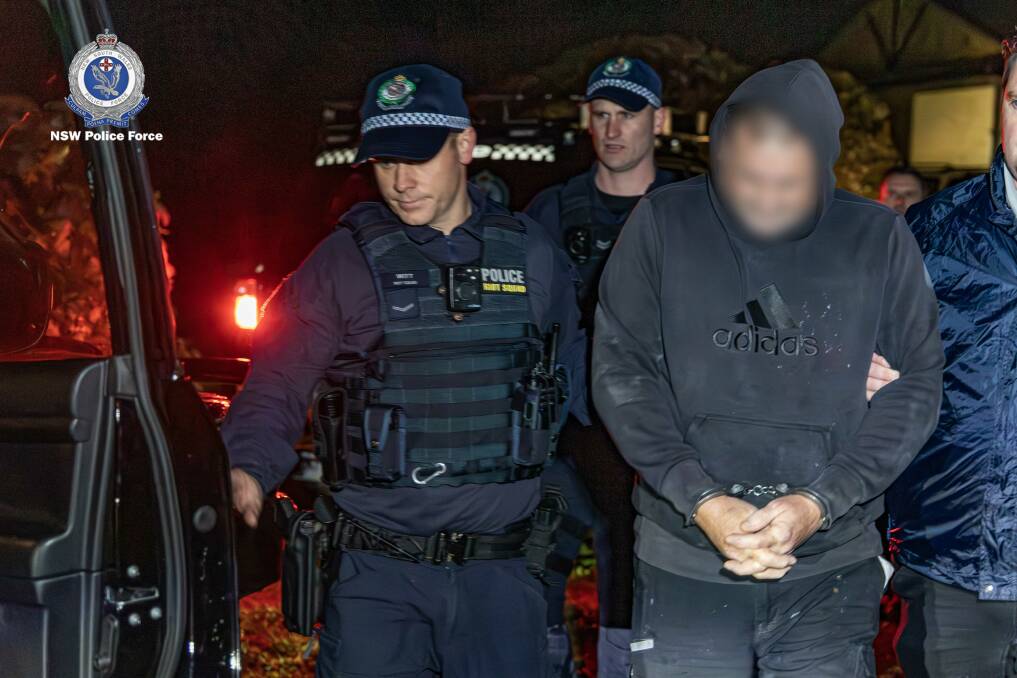 One of the offenders is led away by police after the pre-dawn raid at Marulan. Picture supplied