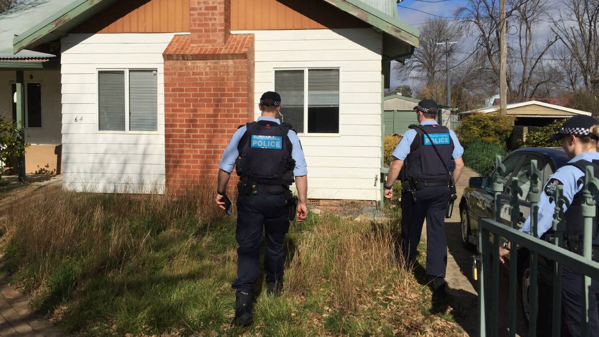 Police officers conducting quarantine checks visit an inner-city residence. Picture: Peter Brewer 