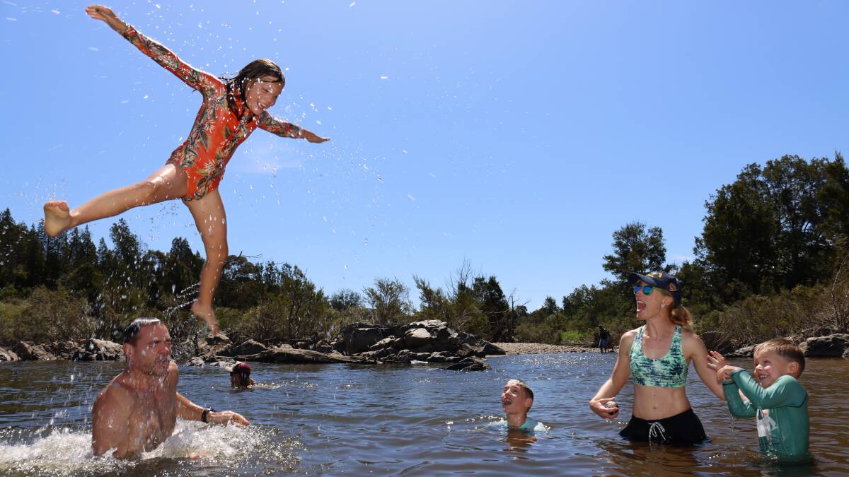 Ben and Miriam Witteveen from Hackett with their children Charlotte, 9, Zac, 12, and Sam, 5, swimming in the Murrumbidgee River at Pine Island Reserve. Picture by James Croucher