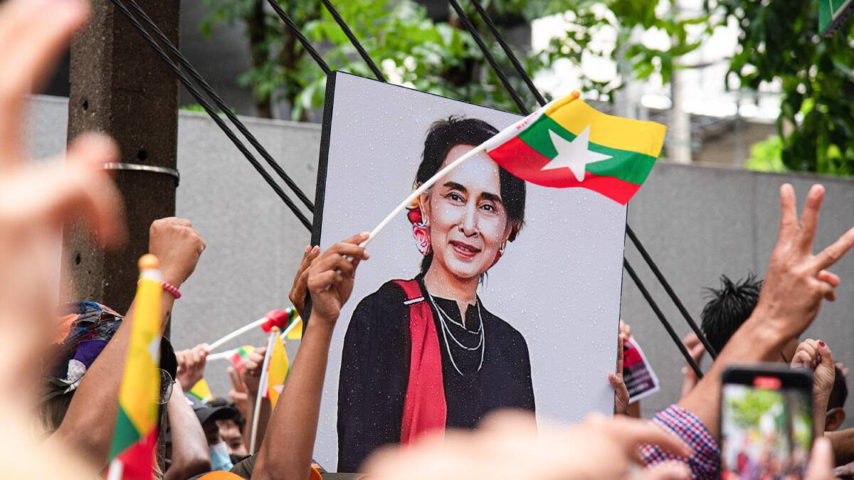 Protesters seen holding a portrait of Aung San Suu Kyi during the demonstration last year. Picture Getty Images 