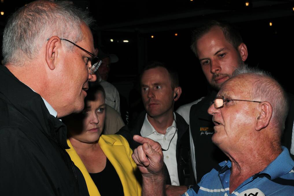 An angry pensioner verbally abuses and finger pokes Prime Minister Scott Morrison in Newcastle. Picture: Peter Lorimer