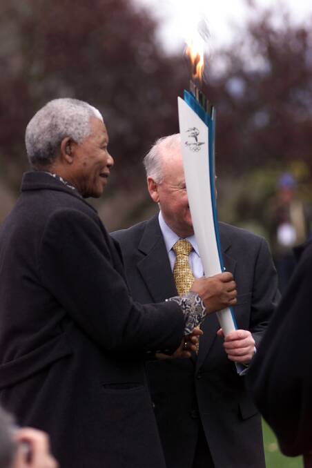 Nelson Mandela holding the torch during a reception at Government House with Governor-General William Deane. Picture: Greg Garay