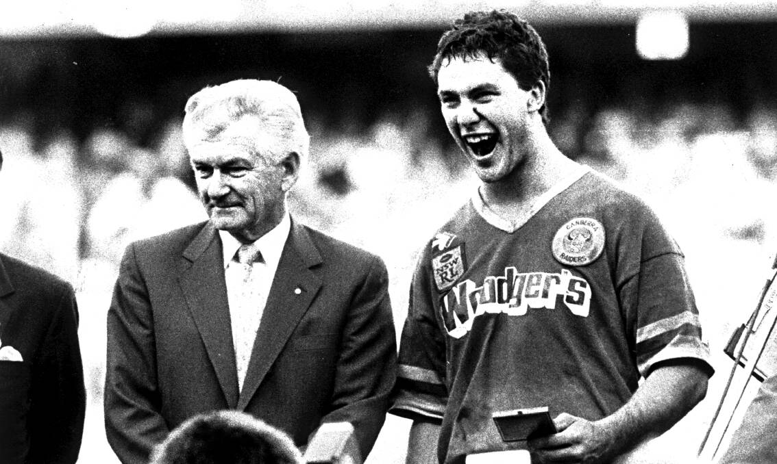Bradley Clyde stands beside the Raiders' then-No. 1 ticket holder after the 1989 triumph.
